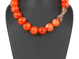 un collier de perles orange sur un mannequin noir