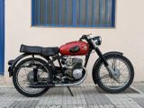 a red and black motorcycle parked in front of a building