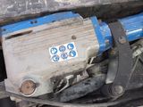 a blue machine that is sitting in the back of a truck