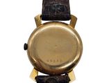 a close up of a gold watch with a black strap