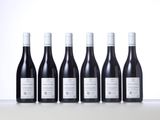 six bottles of wine lined up in a row on a table