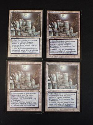 Quatre cartes de Magic : The Gathering sont posées sur une table
