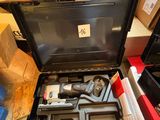 une boîte à outils contenant des outils, posée sur le sol