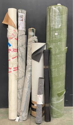 many rolls of fabric on the floor next to each other