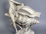 une image représentant une statue d'une femme assise sur un coquillage