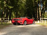 the red sports car is parked on the side of the road