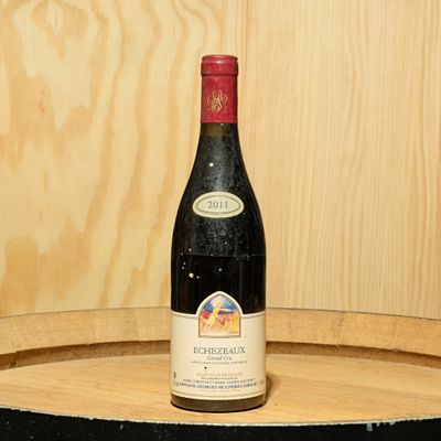 une bouteille de vin posée sur un tonneau en bois