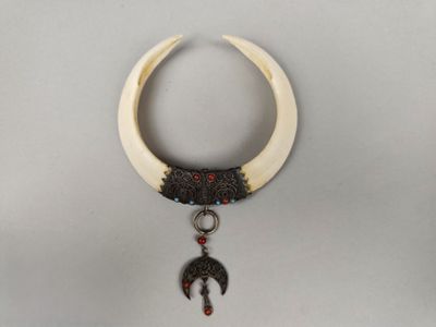 Collier oriental formé de deux dents de phacochère, monture …