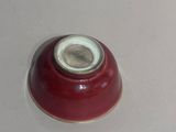 a red bowl with a white lid on a table