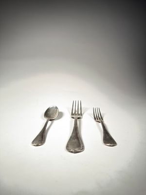 trois fourchettes et une cuillère posées sur une table