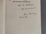 un livre ouvert, sur lequel est inscrit un poème manuscrit, posé sur une table