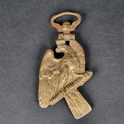 une image représentant un porte-clés en forme d'oiseau doré posé sur une surface noire