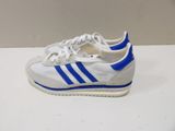 white and blue adidas sneakers on a white surface