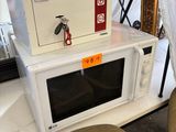 a microwave sitting on top of a table next to a chair