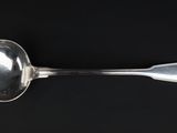 a silver spoon with a spoon handle on a black surface