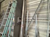 many ladders that are leaning against a wall in a warehouse