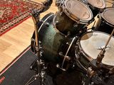 a drum set up in a recording studio with a rug