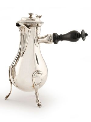 une cafetière ancienne en argent avec une poignée noire sur fond blanc