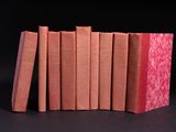 several books are stacked on top of each other on a black surface