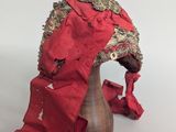 an image of a red hat on a wooden stand with a red ribbon