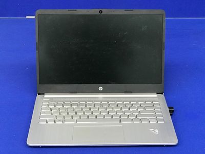 un ordinateur portable ouvert posé sur une surface bleue