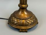 une lampe de table dorée posée sur une table blanche
