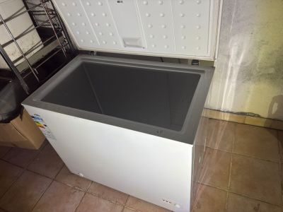 a white chest freezer sitting on a tiled floor