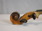 an old violin sitting on top of a white table next to a wall