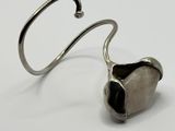 a close up of a metal hook with a heart shaped object on it