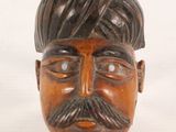 a wooden head of a man with a turban on his head