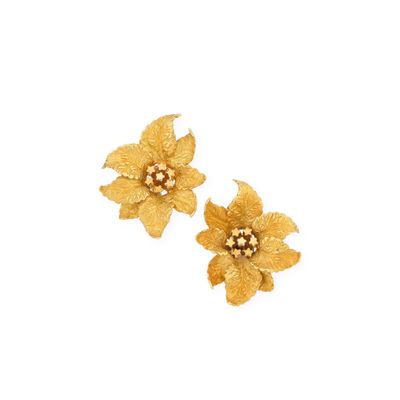 a pair of gold flower earrings on a white background