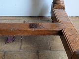 a wooden bench sitting on a tile floor next to a white wall