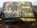 a wooden box with a painting on it sitting on a table