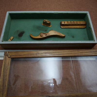 une vitrine posée au sol contenant divers outils