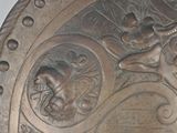 a metal plate with a design on it on a table