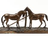 bronze statue of two horses with a plow on a white background