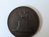 a bronze medal with a horse and rider on it