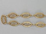 a close up of two gold bracelets on a white surface