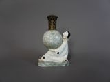 une figurine représentant une femme tenant une boule de verre