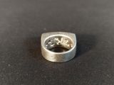 a close up of a silver ring on a black surface