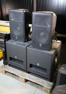 three speakers sitting on a pallet in a room