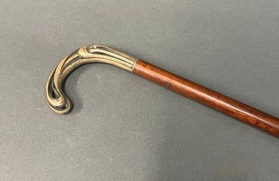 un bâton en bois muni d'un manche en métal, posé sur une table