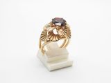 a close up of a gold ring with a garnetite stone