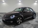 une photo d'une Coccinelle Volkswagen noire garée dans un garage