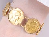 bracelet en pièces d'or au poignet d'une femme, avec une pièce au centre