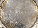 a silver plate that has a chinese writing on it