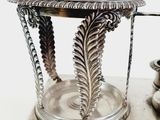 a silver vase with a leaf design on it