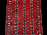 a red and black rug with fringes on a black background