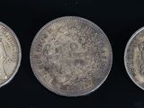 trois pièces d'argent sur lesquelles figurent les portraits d'une femme et d'un homme