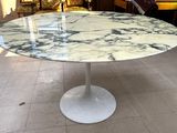 a marble table with a white base in the middle of a room